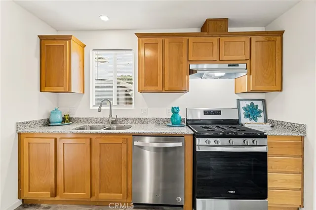 a kitchen with stainless steel appliances granite countertop a refrigerator and a stove top oven