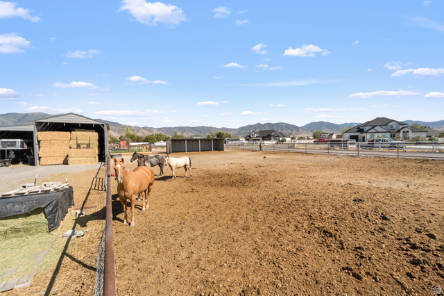 3678 Spiral Springs Road, Unit 204 Tooele, UT 84074 - Photo 51 of 59 Expansive outdoor area featuring a large, fenced enclosure, a covered hay storage structure, and distant mountain scenery