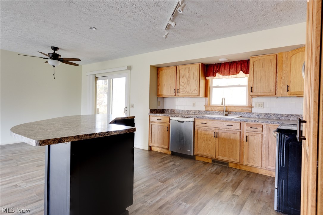 9416 Kieffer Road Mantua, OH 44255 - Photo 14 of 29 Kitchen with track lighting, range, a textured ceiling, decorative backsplash, and light wood-style flooring