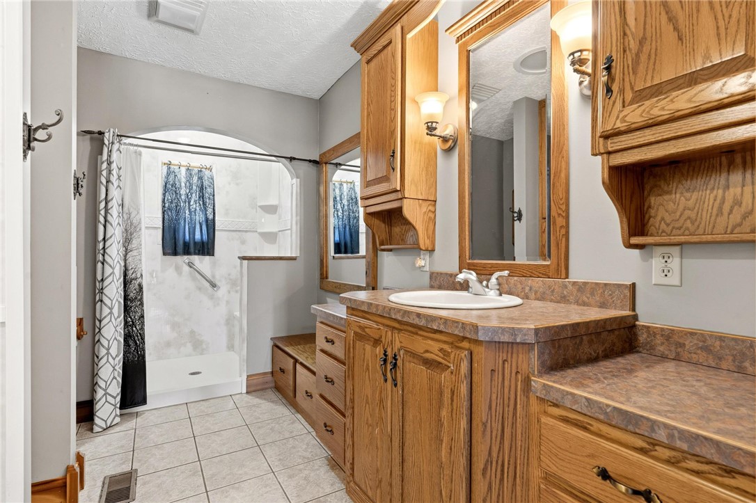 4971 Lackey Road Cedarville, OH 45314 - Photo 62 of 79 This bright bathroom features a spacious shower and ample vanity space with natural wood cabinetry.
