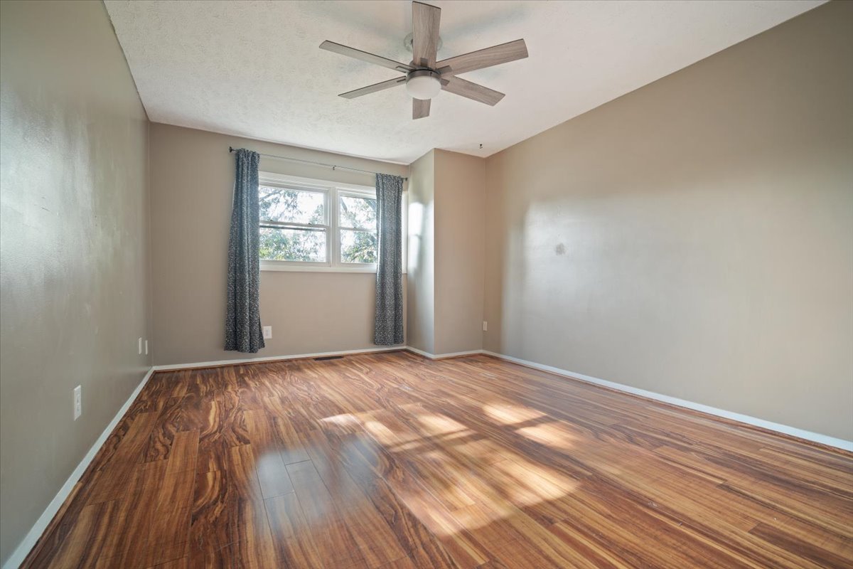 1707 King Drive, Unit D Normal, IL 61761 - Photo 12 of 24 a view of empty room with wooden floor and fan