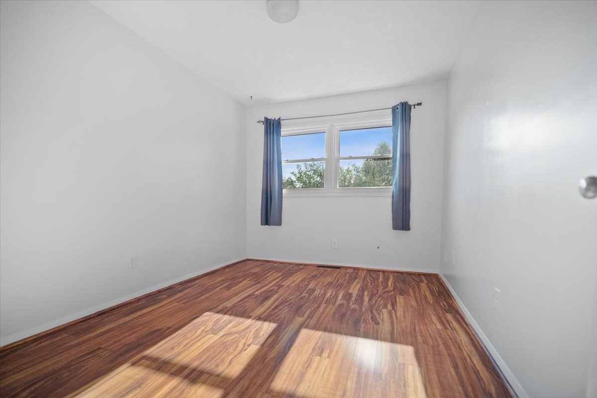 1707 King Drive, Unit D Normal, IL 61761 - Photo 13 of 24 a view of an empty room with wooden floor and a window