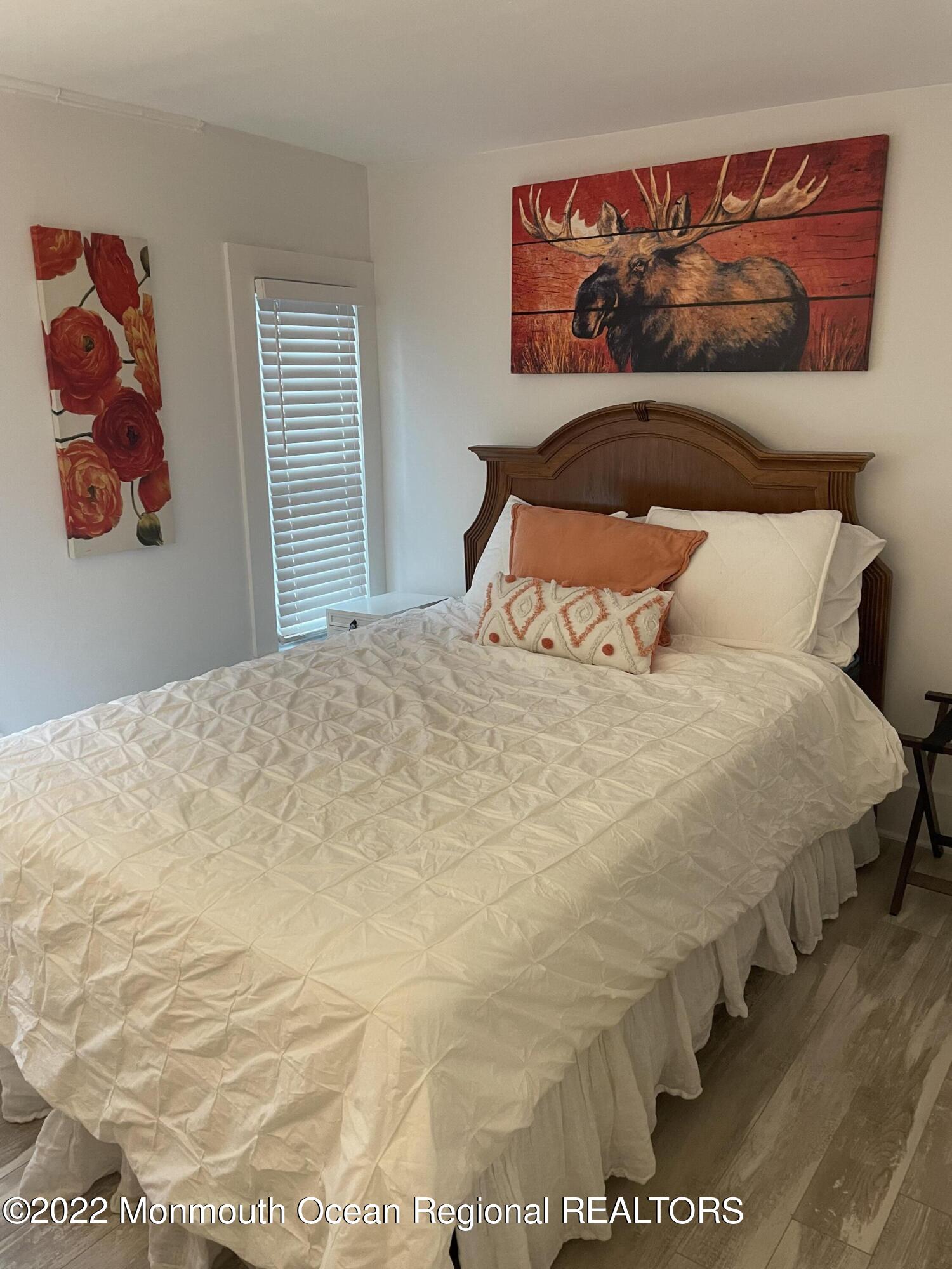 143 Mt Hermon Way, Unit 1/2 Ocean Grove, NJ 07756 - Photo 13 of 26 a bedroom with a bed and a wall painting