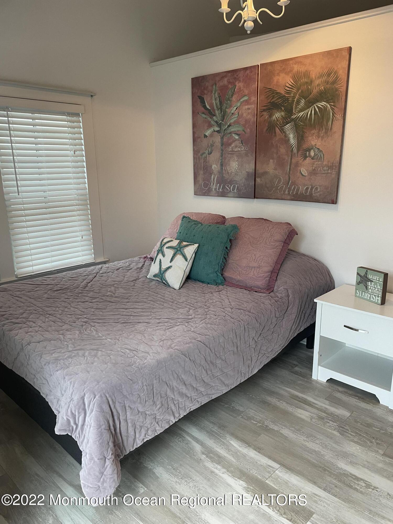 143 Mt Hermon Way, Unit 1/2 Ocean Grove, NJ 07756 - Photo 19 of 26 a bedroom with a bed and painting on the wall