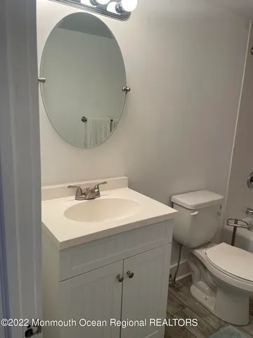 a bathroom with a sink a toilet and a mirror