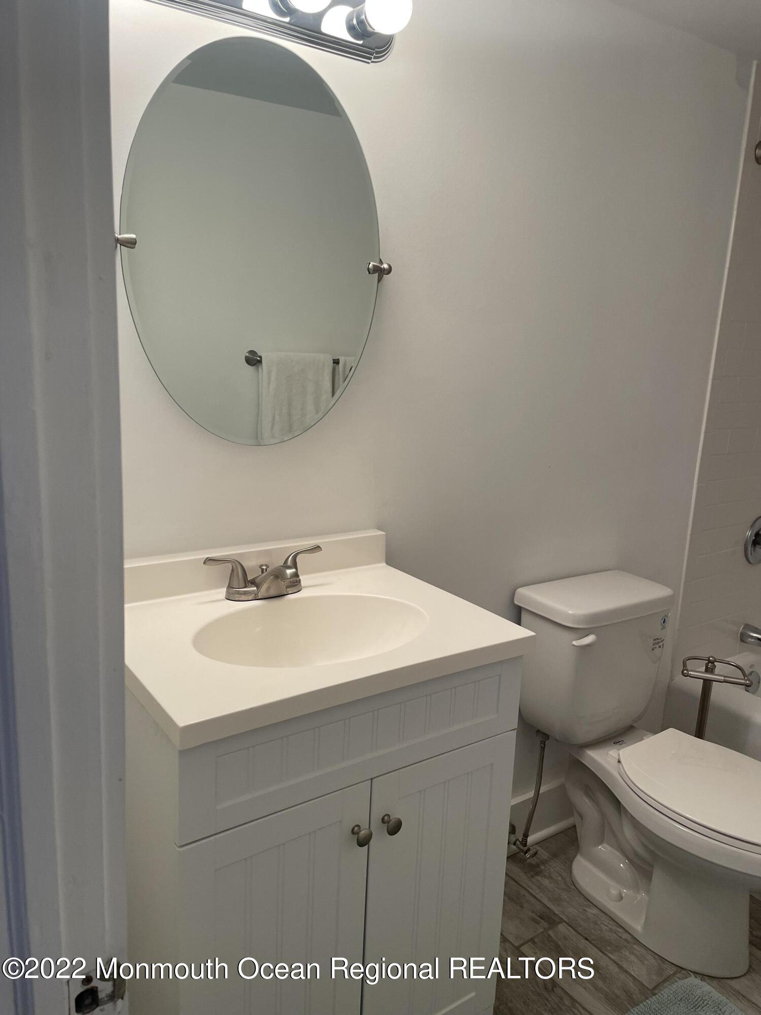 143 Mt Hermon Way, Unit 1/2 Ocean Grove, NJ 07756 - Photo 22 of 26 a bathroom with a sink a toilet and a mirror