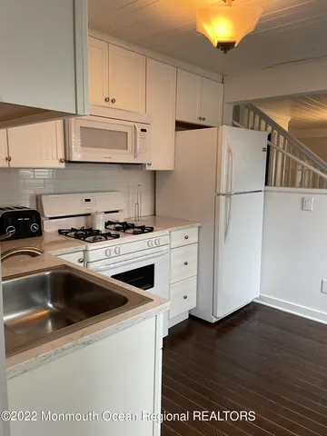 a kitchen with a refrigerator sink and cabinets