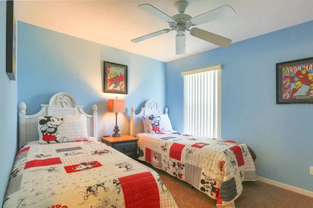 a bedroom with two beds and a chandelier