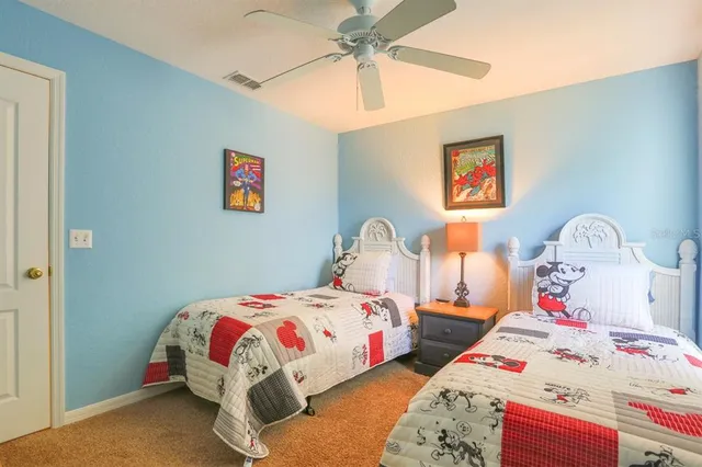 a bedroom with a bed and a lamp on the dresser