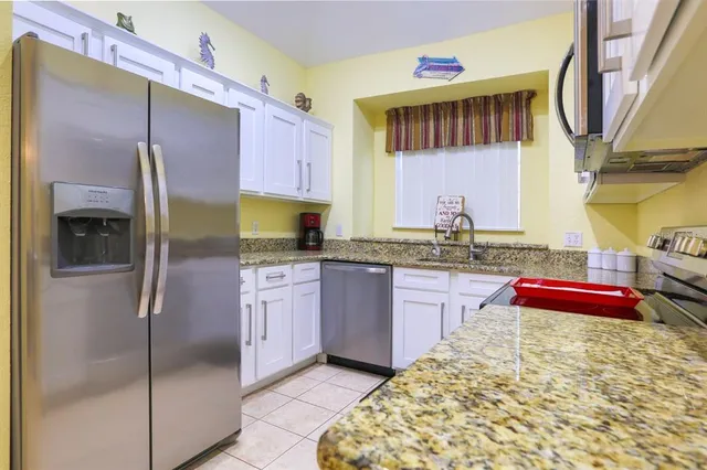 a kitchen with kitchen island granite countertop wooden cabinets and a refrigerator