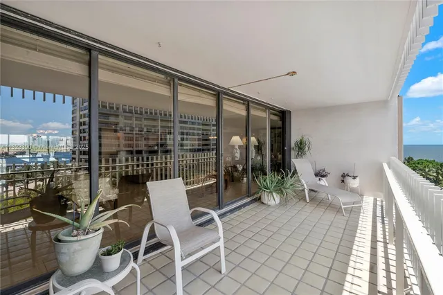 a balcony with chairs and with potted plants