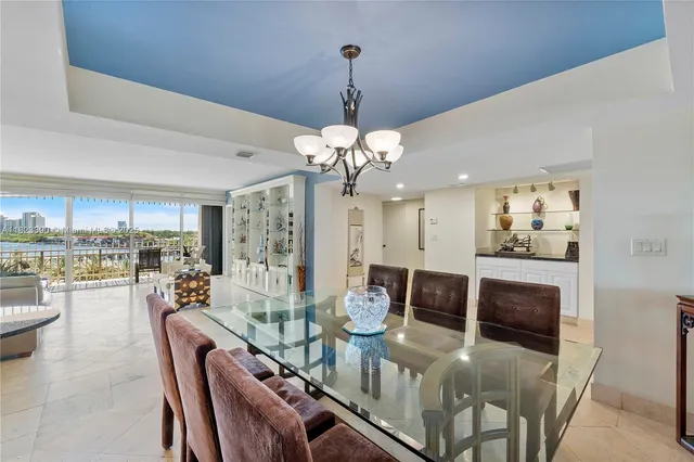 a living room with furniture a chandelier and a dining room