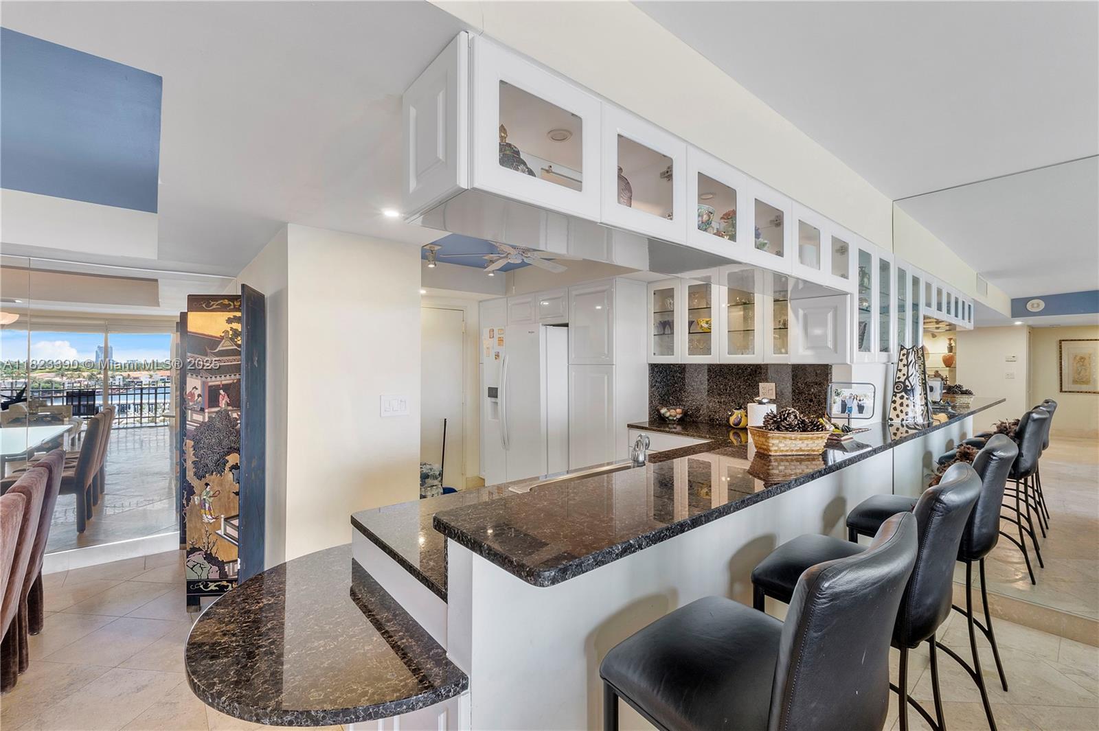 3 Grove Isle Drive, Unit C706 Miami, FL 33133 - Photo 9 of 20 a kitchen with stainless steel appliances granite countertop a table and chairs