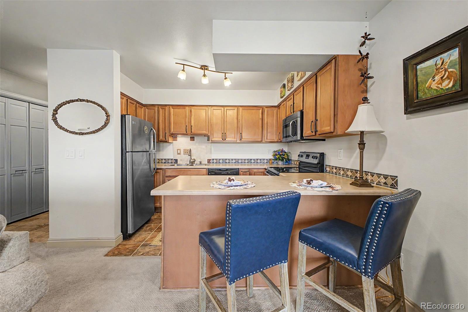 31270 John Wallace Road, Unit 412 Evergreen, CO 80439 - Photo 11 of 38 a kitchen with stainless steel appliances granite countertop a sink a stove a refrigerator cabinets and dining room view