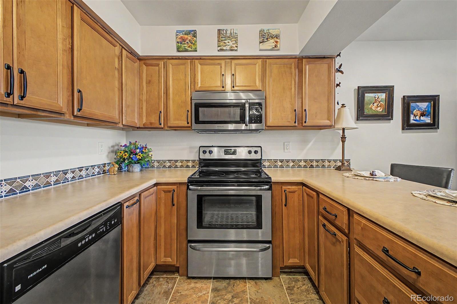 31270 John Wallace Road, Unit 412 Evergreen, CO 80439 - Photo 13 of 38 a kitchen with granite countertop a sink stove and microwave