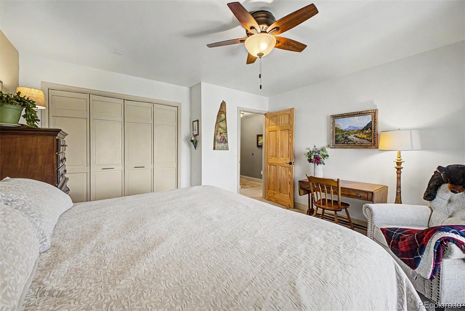 31270 John Wallace Road, Unit 412 Evergreen, CO 80439 - Photo 16 of 38 a bedroom with a bed and a chandelier