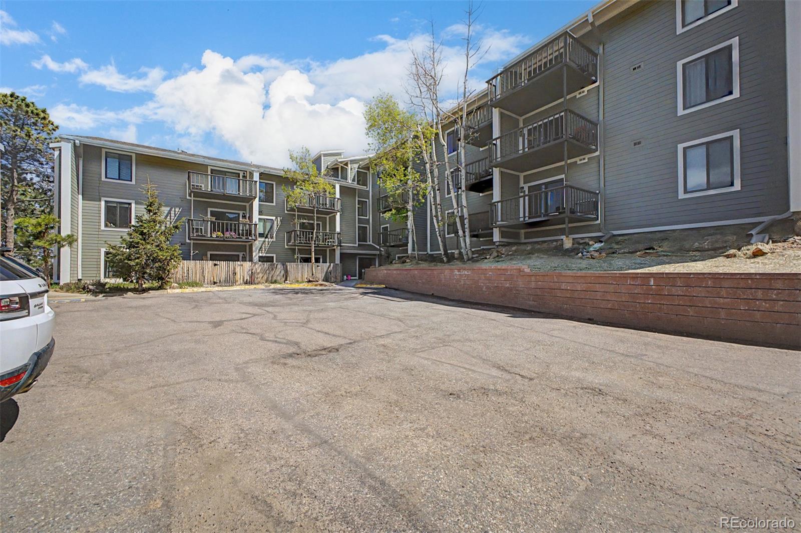 31270 John Wallace Road, Unit 412 Evergreen, CO 80439 - Photo 2 of 38 a large building with a large tree in front of it