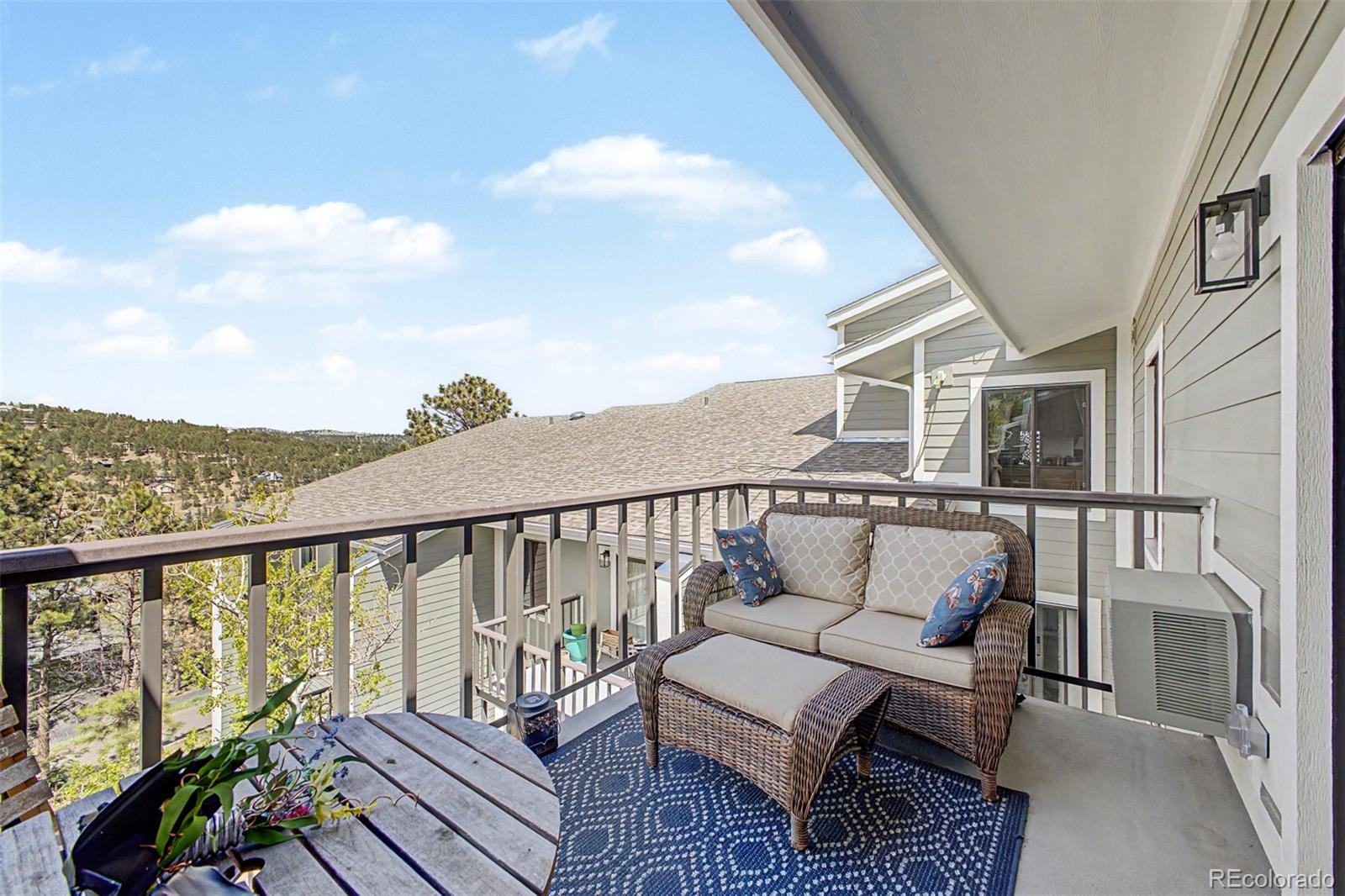 31270 John Wallace Road, Unit 412 Evergreen, CO 80439 - Photo 22 of 38 a balcony of a house with wooden floor outdoor seating and barbeque oven