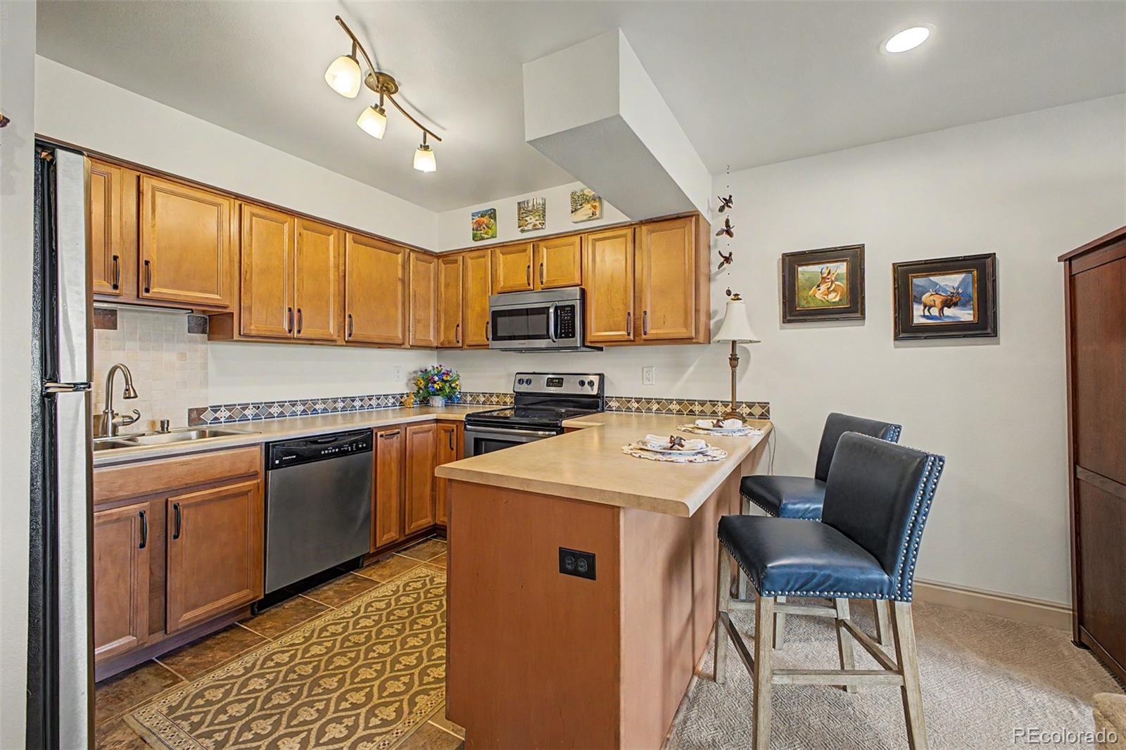 31270 John Wallace Road, Unit 412 Evergreen, CO 80439 - Photo 10 of 38 a kitchen that has a cabinets and a stove top oven