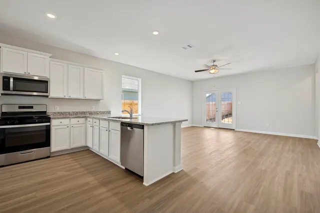 a kitchen with stainless steel appliances a refrigerator and a stove top oven