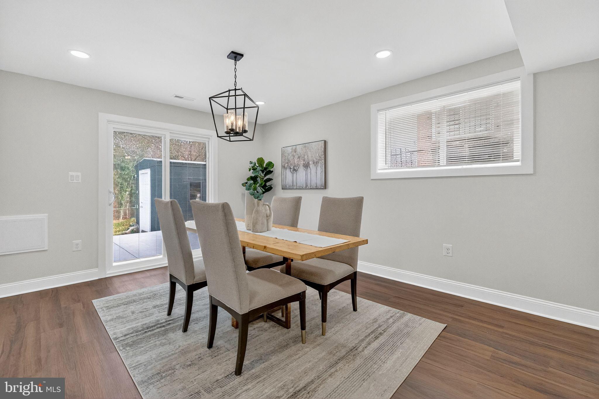 3240 Pope Street Southeast Washington, DC 20020 - Photo 13 of 40 a dining room with wooden floor a chandelier a wooden table and chairs
