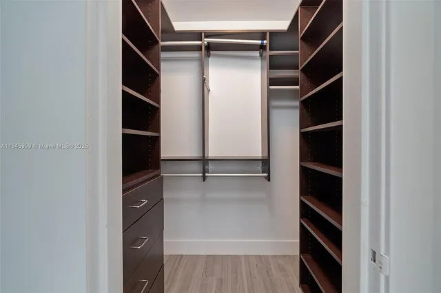 a view of walk in closet with empty racks