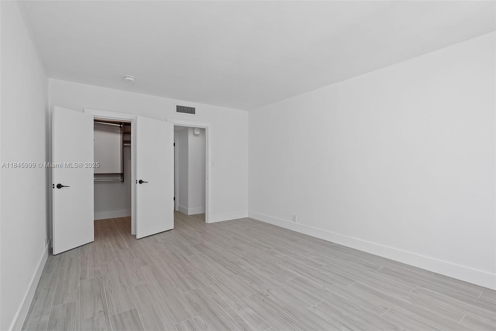 1200 West Avenue, Unit 521 Miami Beach, FL 33139 - Photo 20 of 51 a view of an empty room with wooden floor and closet