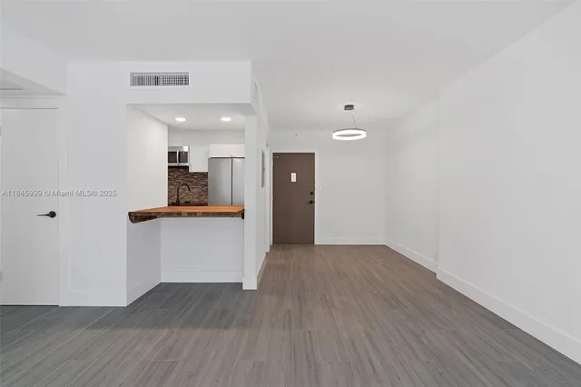 a view of kitchen with wooden floor and electronic appliances