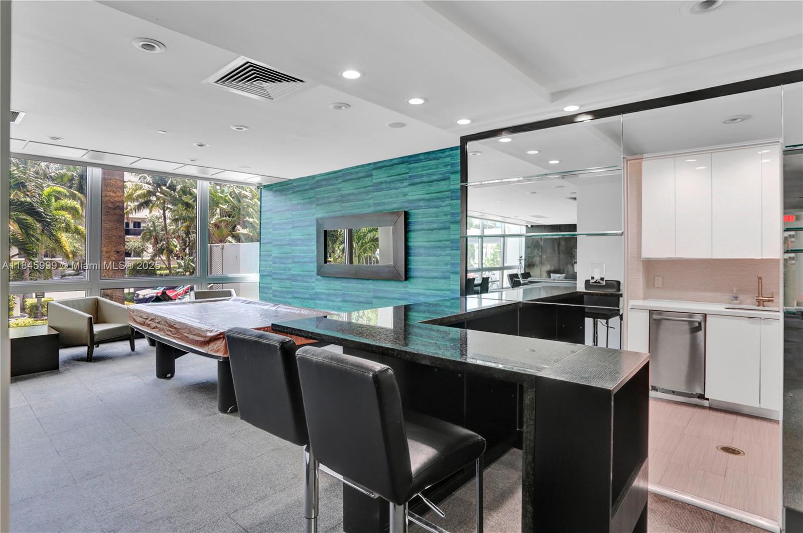 1200 West Avenue, Unit 521 Miami Beach, FL 33139 - Photo 32 of 51 a kitchen with a table chairs sink and cabinets