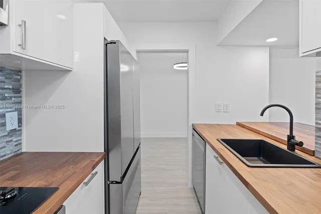 a kitchen with stainless steel appliances kitchen island a stove top oven and sink