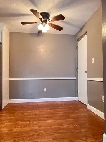 a view of a room with a ceiling fan and wooden floor