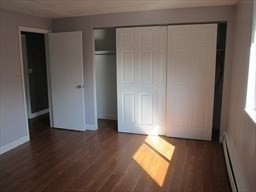 40 Colonial Drive, Unit 8 Andover, MA 01810 - Photo 14 of 19 an empty room with wooden floor and windows