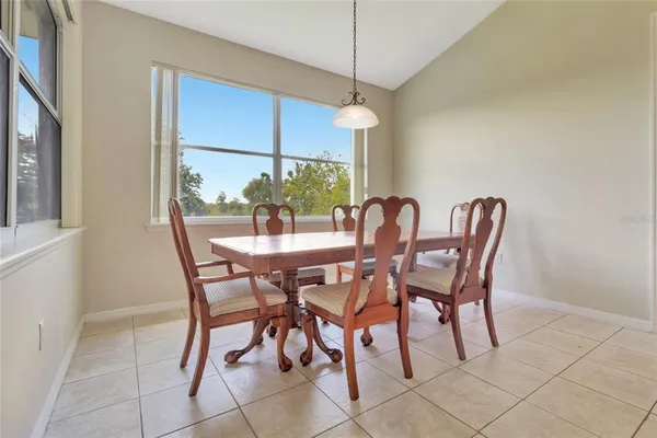a view of a dining room and livingroom with furniture wooden floor a chandelier