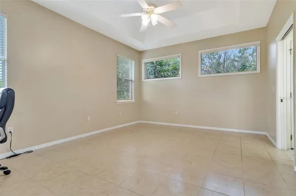 an empty room with windows and fan