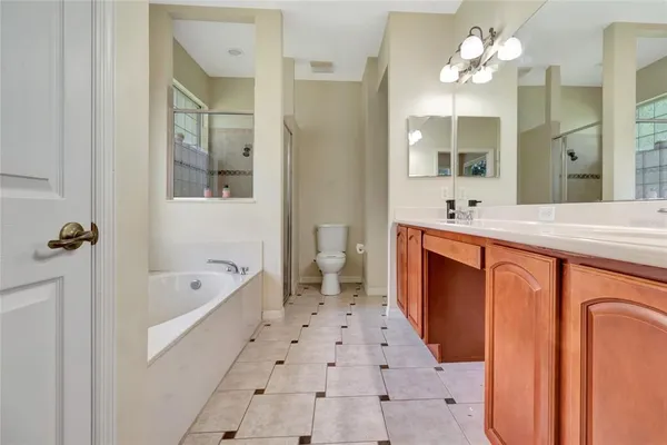 a spacious bathroom with a bathtub sink and mirror