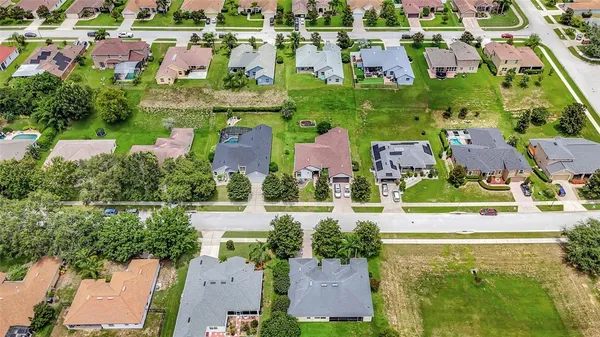 an aerial view of residential houses with outdoor space and swimming pool