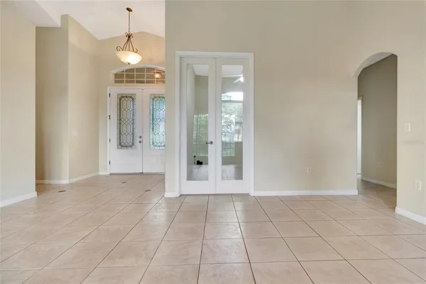 a view of a hallway with wooden floor and a living room