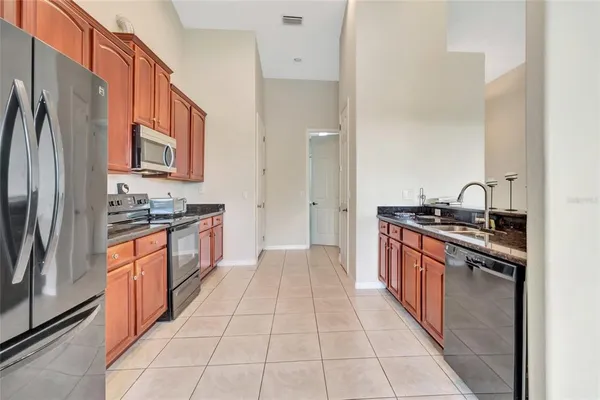 a large kitchen with stainless steel appliances granite countertop a refrigerator and a stove top oven
