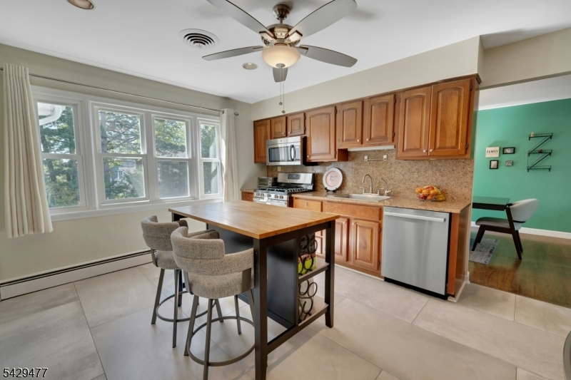 10 Ronald Terrace Springfield, NJ 07081 - Photo 11 of 36 a kitchen with a stove a sink a dining table and chairs