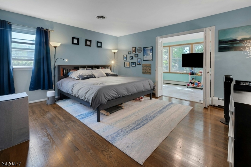 10 Ronald Terrace Springfield, NJ 07081 - Photo 15 of 36 a spacious bedroom with a bed and a flat screen tv