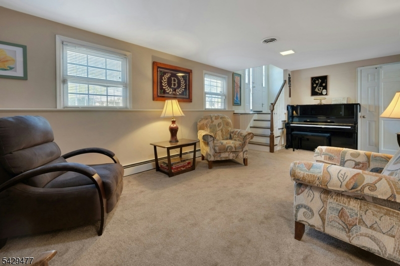 10 Ronald Terrace Springfield, NJ 07081 - Photo 22 of 36 a living room with furniture and a flat screen tv with kitchen view