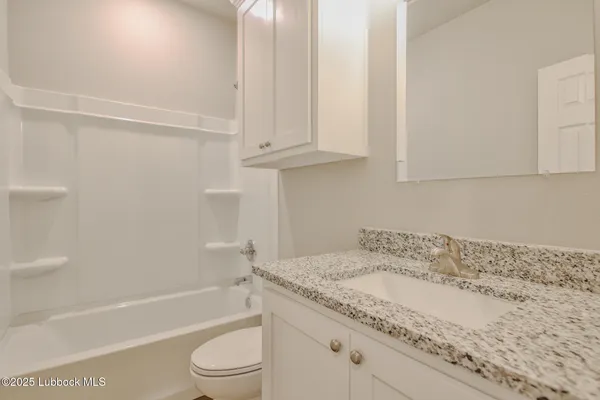 a bathroom with a granite countertop sink toilet and bathtub