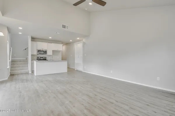 a view of kitchen with refrigerator and white cabinets