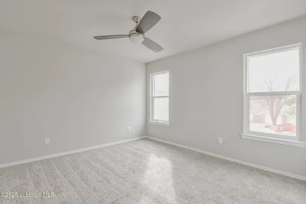 an empty room with a window and ceiling fan