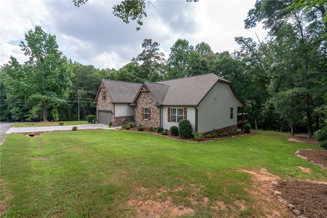 201 Hearthstone Drive Anderson, SC 29621 - Photo 48 of 49 A well-maintained home featuring a stone and siding facade, nestled among mature trees with a neat front lawn.