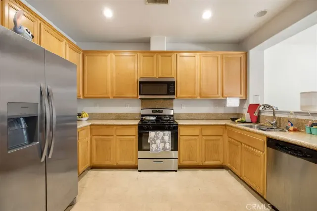 a kitchen with stainless steel appliances a sink stove and cabinets