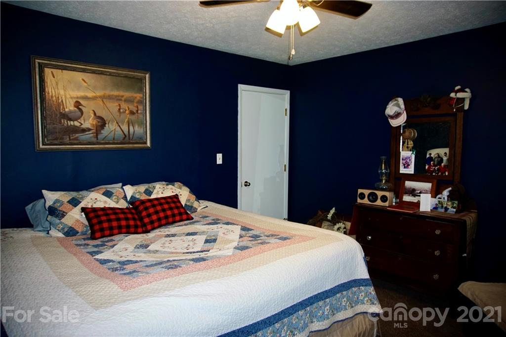 3038 Dravo Road Shelby, NC 28152 - Photo 14 of 33 a bedroom with a bed and a chandelier