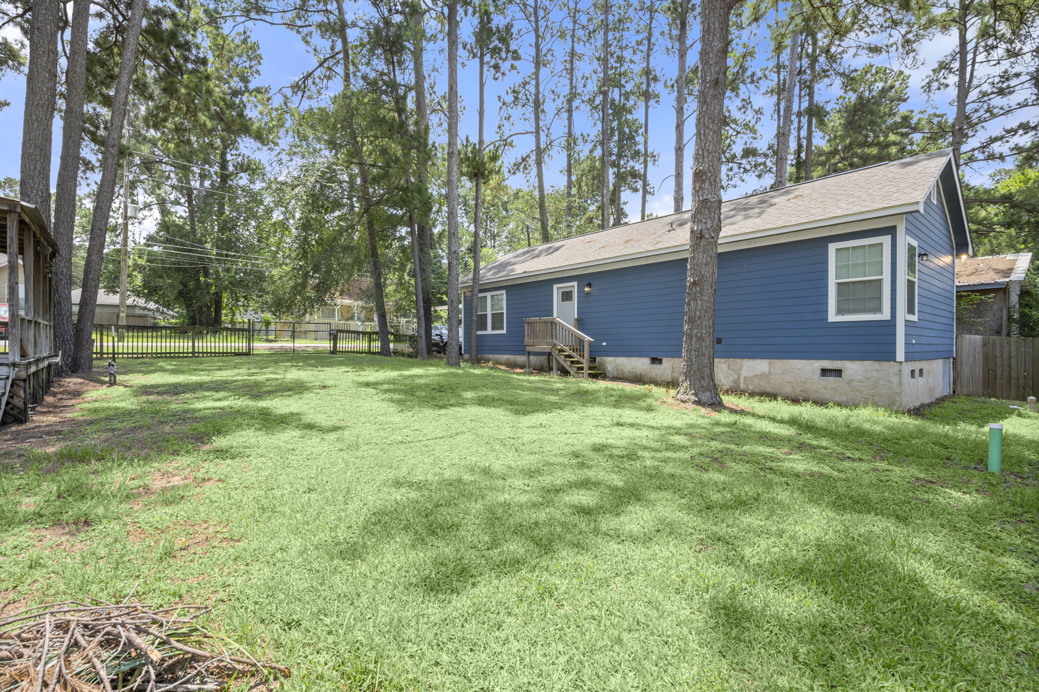 9649 Warm Spring Willis, TX 77318 - Photo 3 of 30 A deep blue siding and mature trees frame this peaceful, spacious yard.