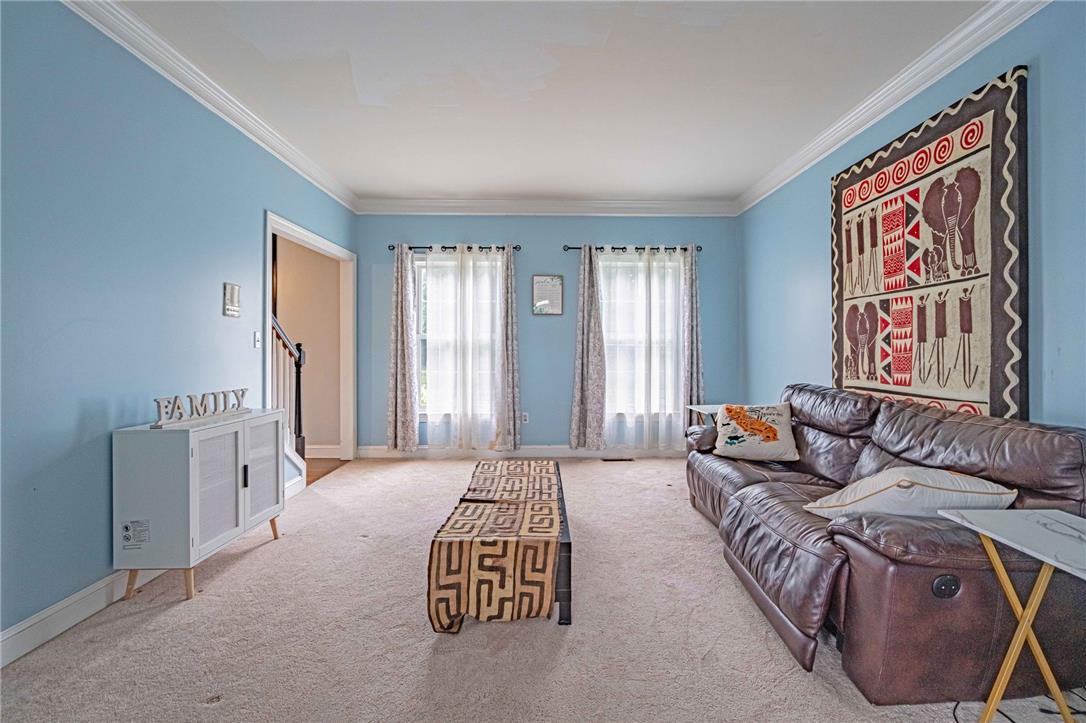 102 Sutton Road Easton, PA 18045 - Photo 13 of 83 Crisp crown molding highlights this welcoming living space featuring soft neutral carpeting and dual windows.