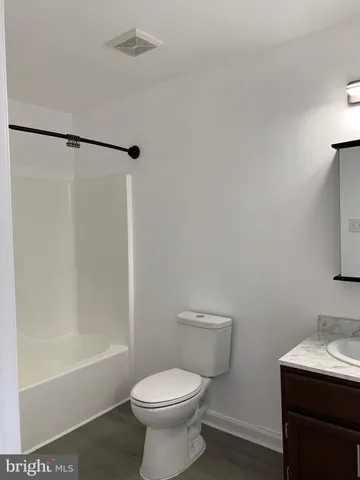 a white toilet sitting next to a bath tub